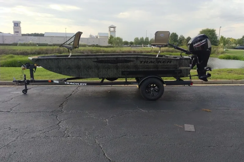 The Image of 2027 Tracker Grizzly 1650 T Prairie Wings Edition boat on trailer, parked outdoors. - 0