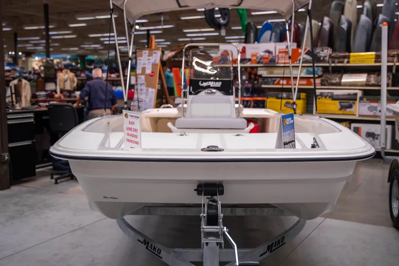 Slide: The Image of 2027 Mako Pro Skiff 17 CC boat displayed indoors with financing sign. - 2