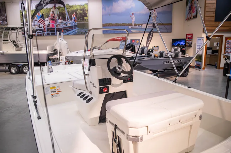 Slide: The Image of 2027 Mako Pro Skiff 17 CC boat displayed in a showroom. - 8