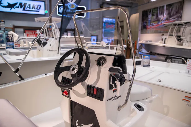 Slide: The Image of 2027 Mako Pro Skiff 17 CC boat interior with steering wheel and controls. - 9