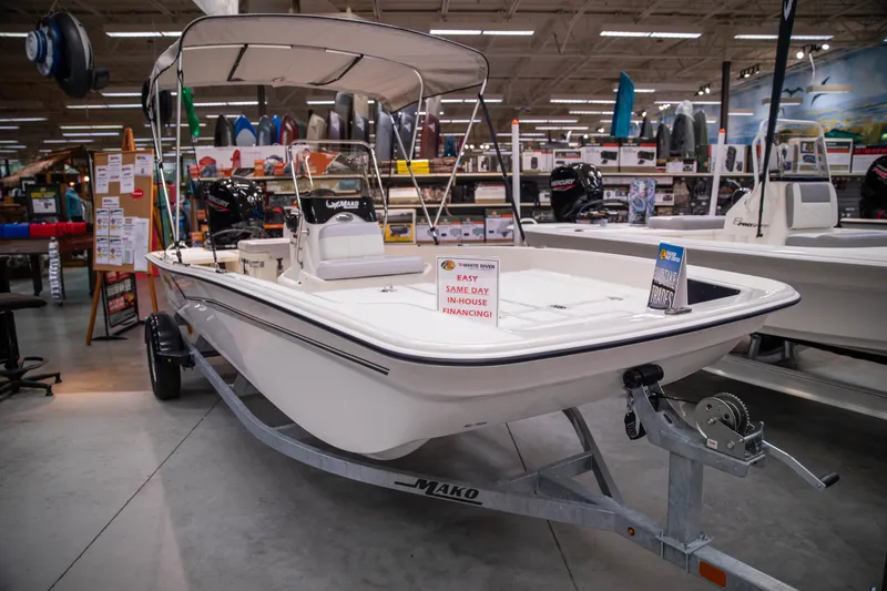 Slide: The Image of 2027 Mako Pro Skiff 17 CC boat displayed indoors with financing sign. - 1