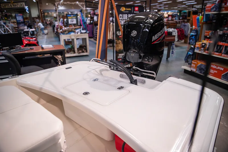 Slide: The Image of 2027 Mako Pro Skiff 17 CC boat displayed in a store with Mercury engine. - 7