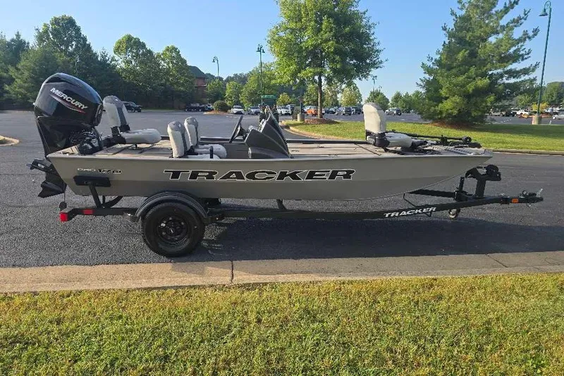 The Image of 2027 Tracker Pro 170 boat on trailer in a parking lot, surrounded by trees. - 0