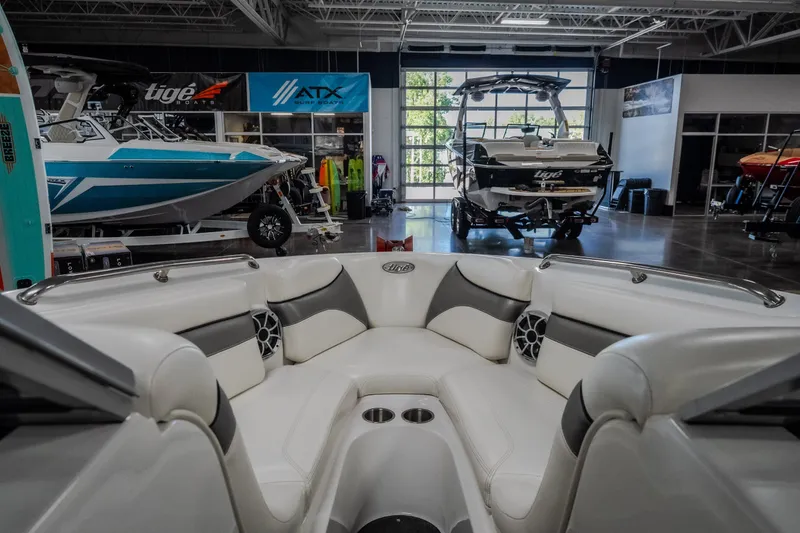 Slide: The Image of Interior view of a 2008 Tigé 24Ve boat in a showroom with other boats. - 16