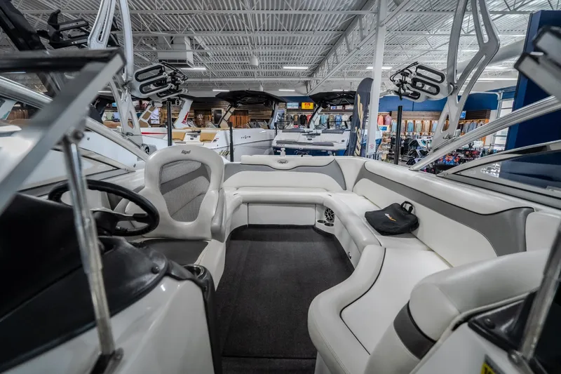 Slide: The Image of 2008 Tigé 24Ve boat interior with white seating and steering wheel in showroom. - 18