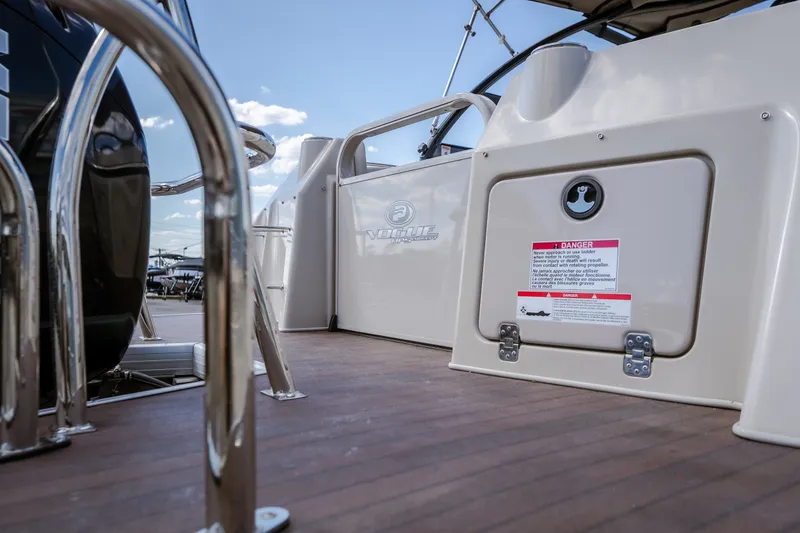 Slide: The Image of 2017 Princecraft Vogue 25 XT boat deck with safety warning label and railing. - 17