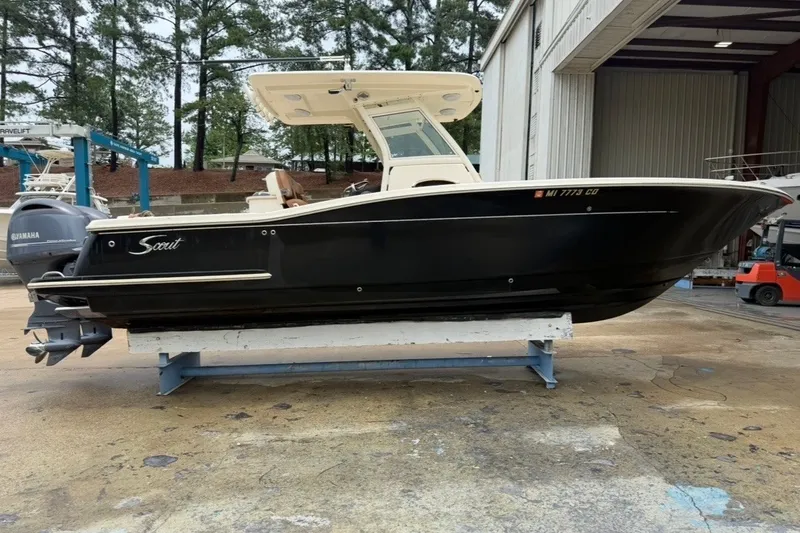 Slide: The Image of 2014 Scout 275 LXF boat on a stand, side view, in a marina setting. - 3