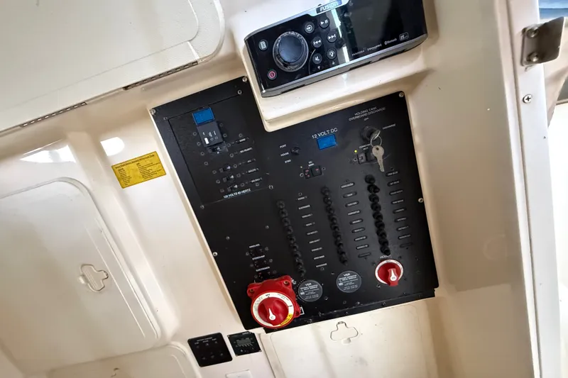 Slide: The Image of Control panel of a 2014 Scout 275 LXF boat, featuring switches and a Fusion audio system. - 11
