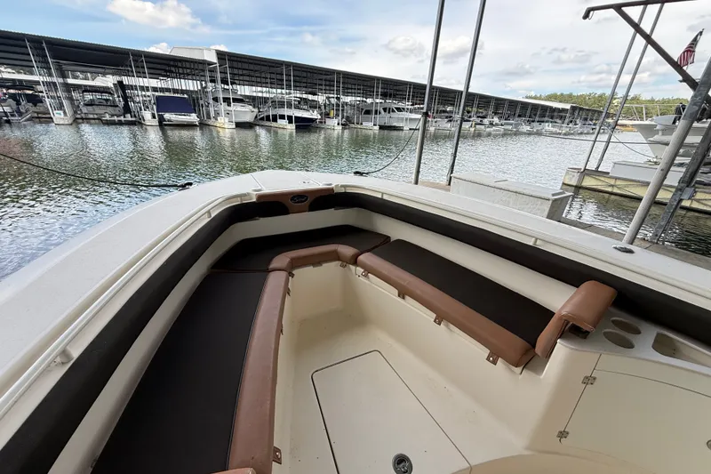 Slide: The Image of 2014 Scout 275 LXF boat interior with brown seating, docked at marina. - 8