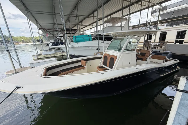 Slide: The Image of 2014 Scout 275 LXF boat docked in a marina under a covered shelter. - 12