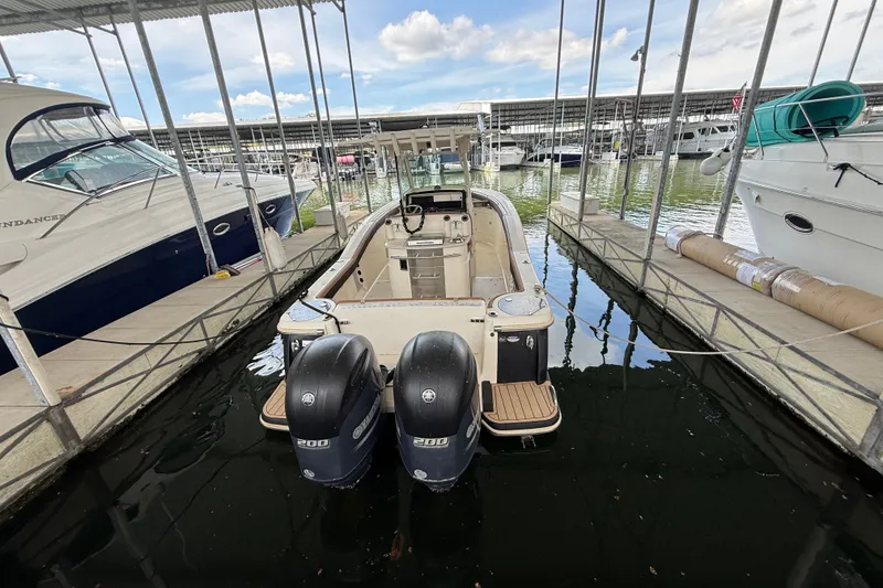Slide: The Image of 2014 Scout 275 LXF boat docked with twin engines in a marina. - 14