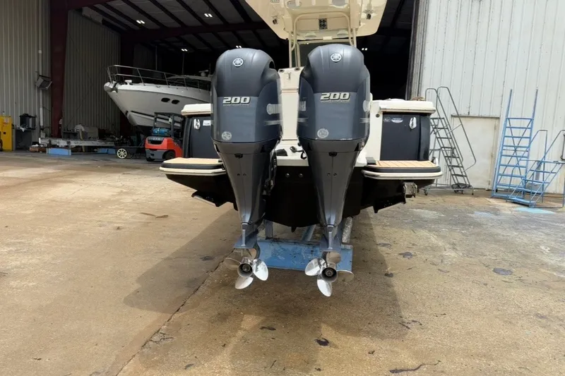 Slide: The Image of 2014 Scout 275 LXF boat with dual 200 horsepower outboard engines in a storage facility. - 2