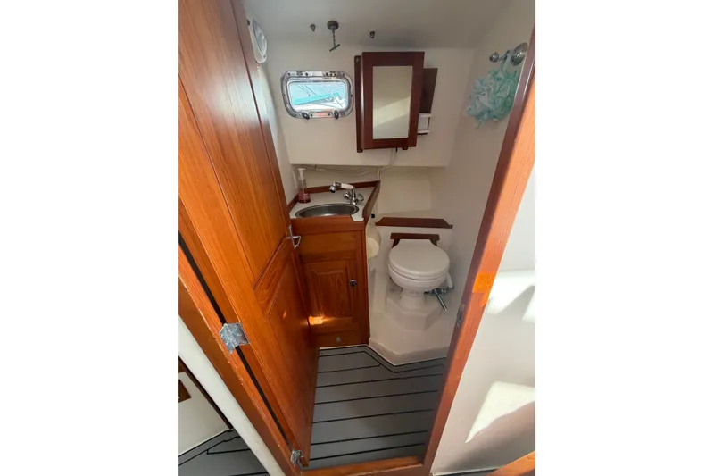 Slide: The Image of Compact bathroom in 2000 Webber's Cove Pemaquid Beach boat with wooden cabinetry and porthole window. - 26
