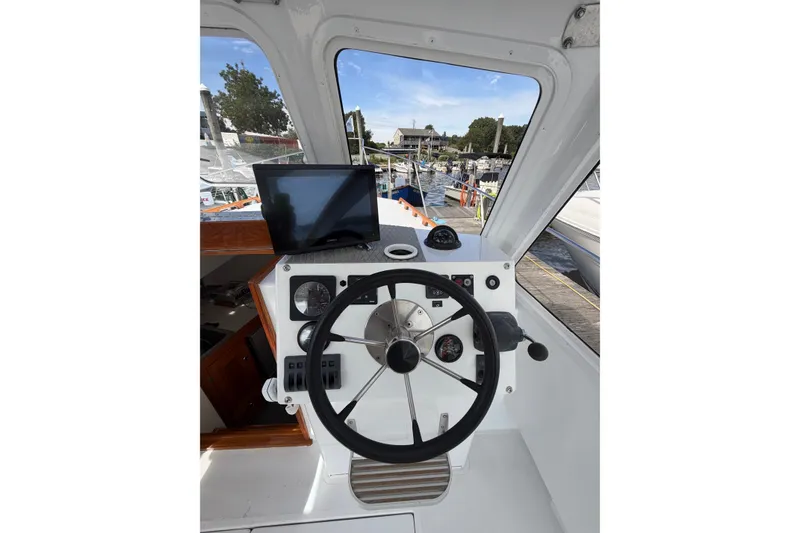 Slide: The Image of Helm of 2000 Webber's Cove Pemaquid Beach boat with steering wheel and navigation equipment. - 19