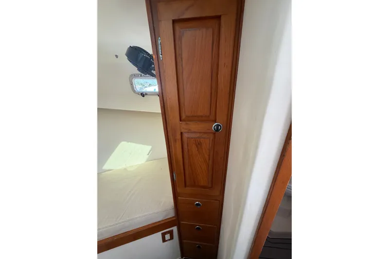 Slide: The Image of Wooden cabin interior of 2000 Webber's Cove Pemaquid Beach boat, featuring storage and a window. - 25