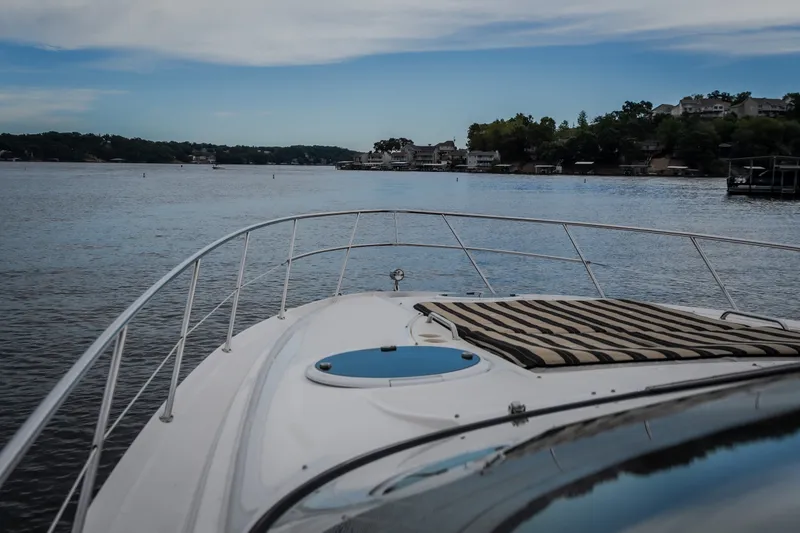 Slide: The Image of 2009 Regal Commodore 4460 yacht cruising on a serene lake under a blue sky. - 30