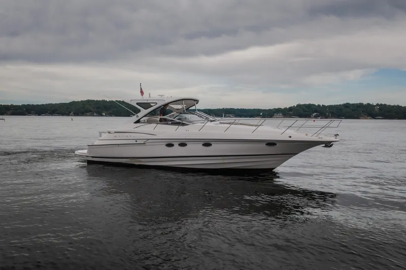 Slide: The Image of 2009 Regal Commodore 4460 yacht cruising on a calm lake under cloudy skies. - 65