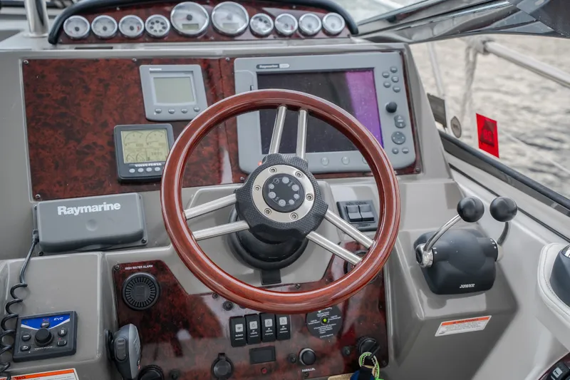Slide: The Image of Control panel of a 2009 Regal Commodore 4460 boat with steering wheel and navigation equipment. - 23