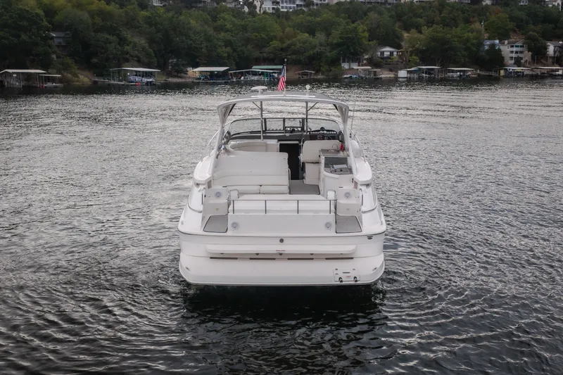 Slide: The Image of 2009 Regal Commodore 4460 yacht on a serene lake, surrounded by lush greenery. - 6