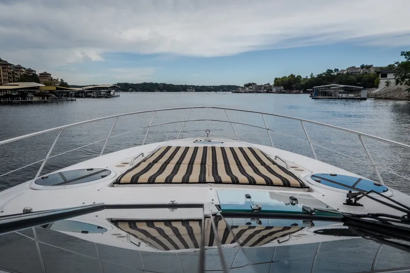 Slide: The Image of 2009 Regal Commodore 4460 yacht cruising on a serene lake with scenic shoreline views. - 27