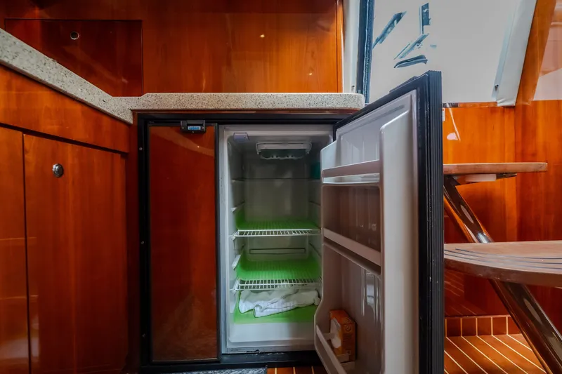Slide: The Image of Open mini fridge in 2009 Regal Commodore 4460 yacht kitchen with wooden cabinetry. - 41
