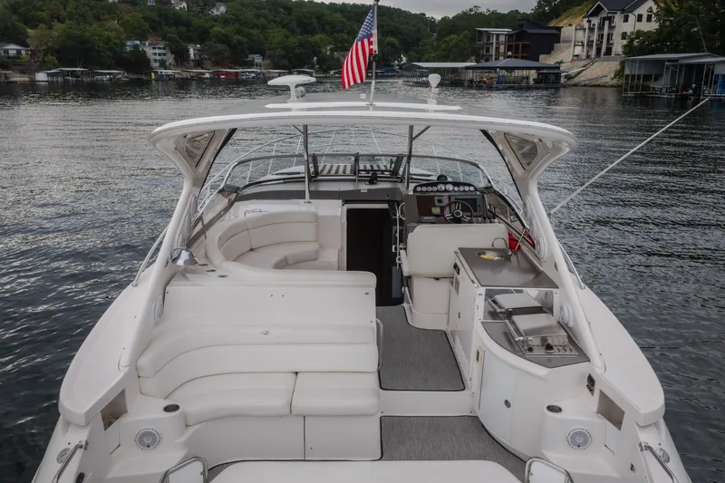 Slide: The Image of 2009 Regal Commodore 4460 yacht interior with seating and kitchenette on a serene lake. - 67