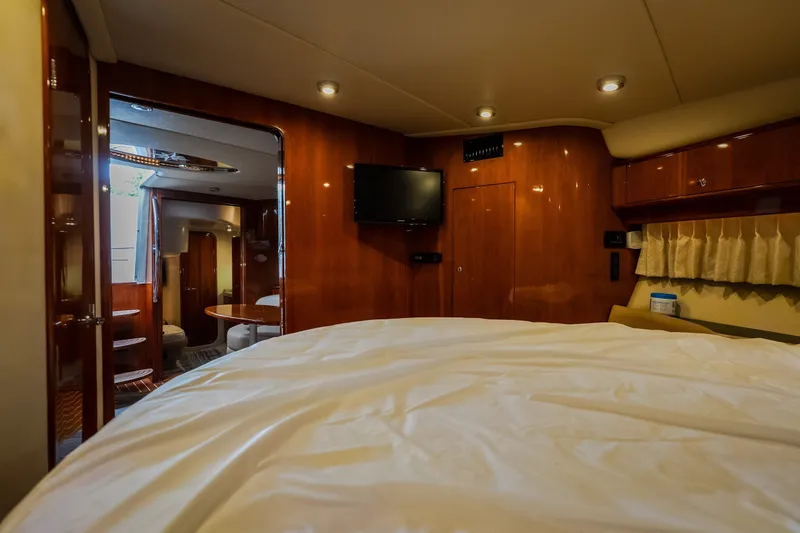 Slide: The Image of Luxurious interior of 2009 Regal Commodore 4460 yacht with wood paneling and cozy bedding. - 49