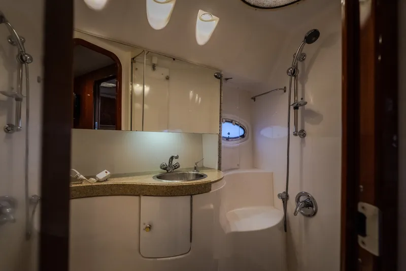 Slide: The Image of Luxurious bathroom in 2009 Regal Commodore 4460 yacht with modern fixtures and porthole window. - 47