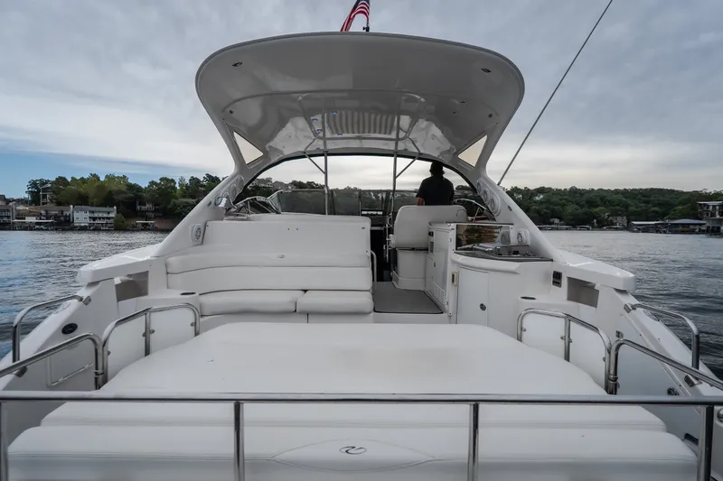 Slide: The Image of 2009 Regal Commodore 4460 yacht with spacious deck on a serene lake. - 7