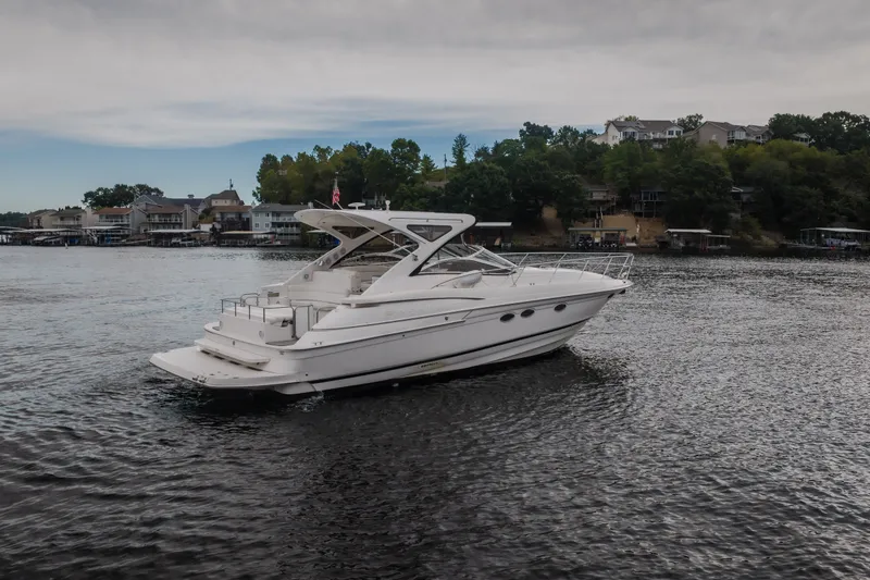 Slide: The Image of 2009 Regal Commodore 4460 yacht cruising on a scenic lake with waterfront homes. - 63