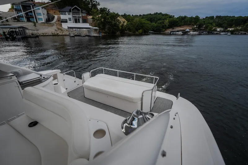 Slide: The Image of 2009 Regal Commodore 4460 yacht cruising on a scenic lake with waterfront homes. - 19