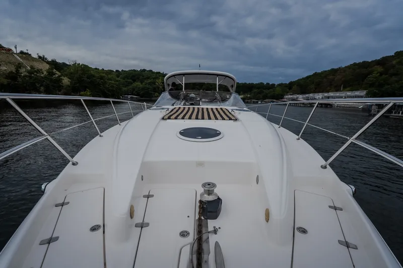Slide: The Image of 2009 Regal Commodore 4460 yacht on a serene river, surrounded by lush greenery. - 32