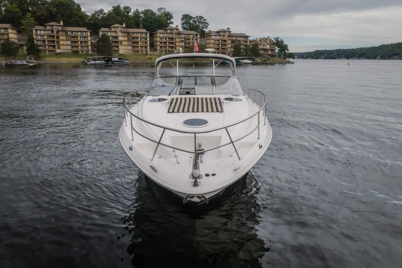 Slide: The Image of 2009 Regal Commodore 4460 yacht on a serene lake with waterfront buildings. - 4