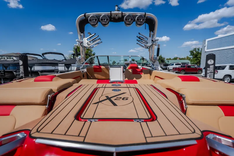 Slide: The Image of 2020 MasterCraft X26 boat with luxurious seating and sleek design under a clear blue sky. - 17