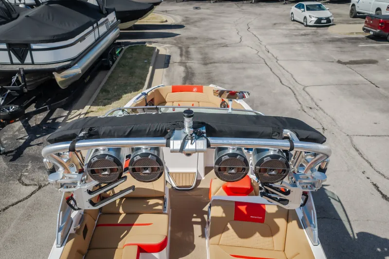Slide: The Image of 2020 MasterCraft X26 boat with premium speakers and tan seating in a parking lot. - 63