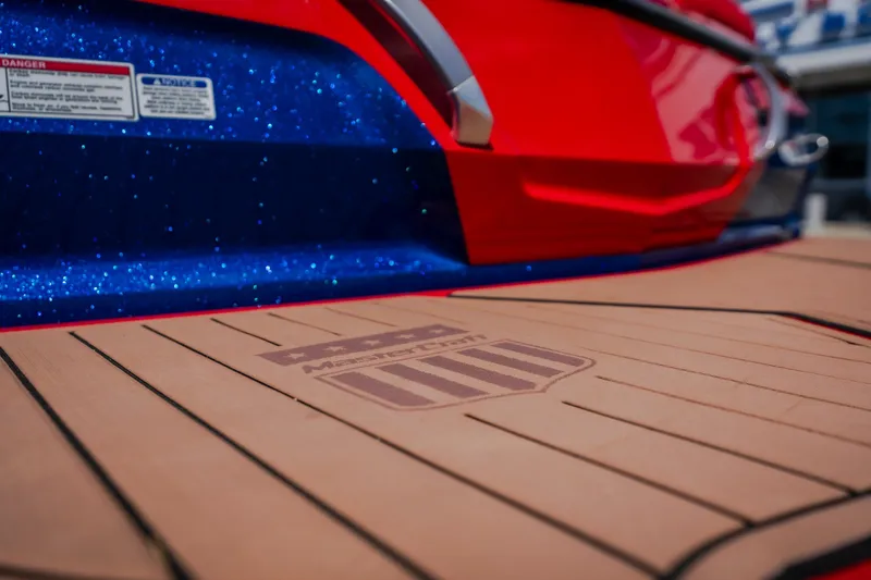 Slide: The Image of 2020 MasterCraft X26 boat with vibrant red and blue detailing, featuring branded deck. - 12
