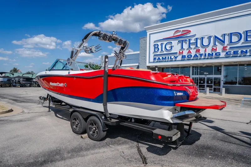 Slide: The Image of 2020 MasterCraft X26 boat in vibrant red and blue at Big Thunder Marine dealership. - 8