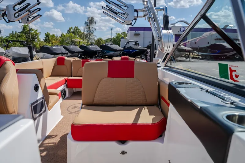Slide: The Image of 2020 MasterCraft X26 boat interior with red and beige seating, under a sunny sky. - 25
