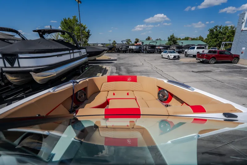 Slide: The Image of 2020 MasterCraft X26 boat with tan and red interior, parked in a marina lot. - 29