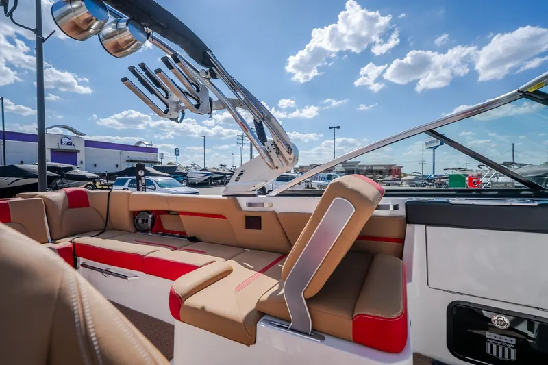 Slide: The Image of 2020 MasterCraft X26 boat interior with red and beige seating under a blue sky. - 40