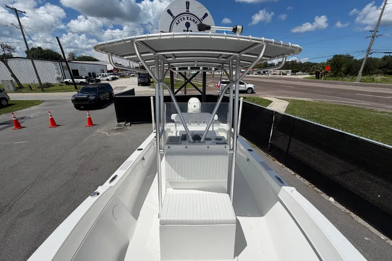 Slide: The Image of 2021 Dusky 227 Open Fisherman boat with T-top, parked outdoors under a blue sky. - 47