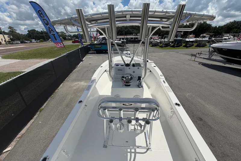 Slide: The Image of 2021 Dusky 227 Open Fisherman boat on display at a dealership under a cloudy sky. - 15