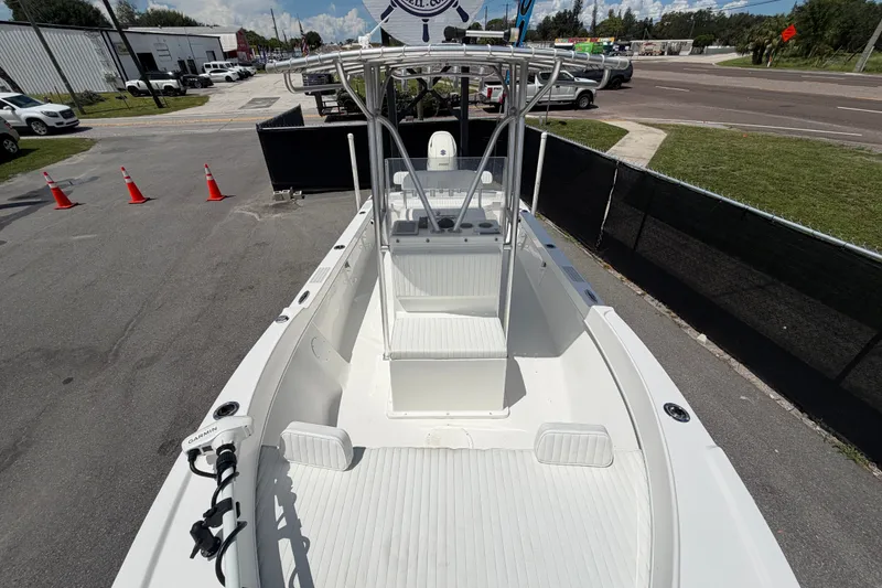 Slide: The Image of 2021 Dusky 227 Open Fisherman boat with T-top, parked on pavement. - 45