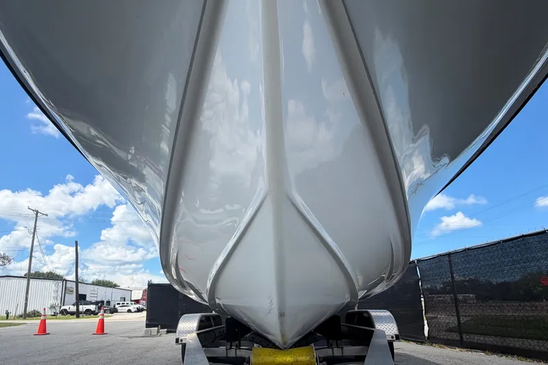 Slide: The Image of The underside of a white boat on a trailer, surrounded by a parking area. - 13
