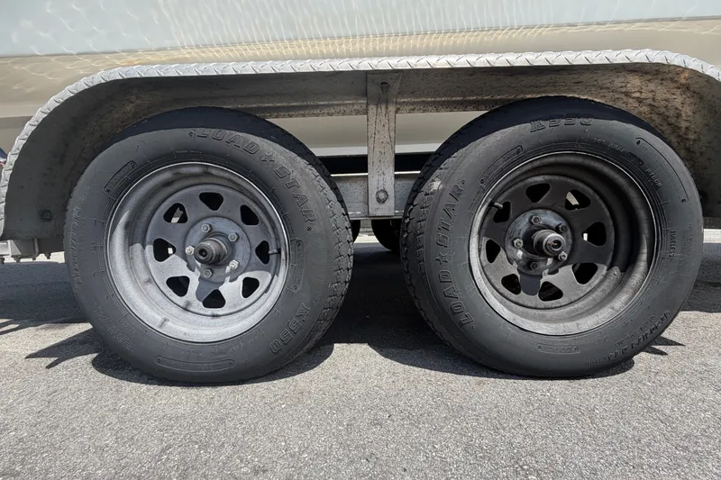 Slide: The Image of Trailer wheels of a 2021 Dusky 227 Open Fisherman boat on asphalt. - 67