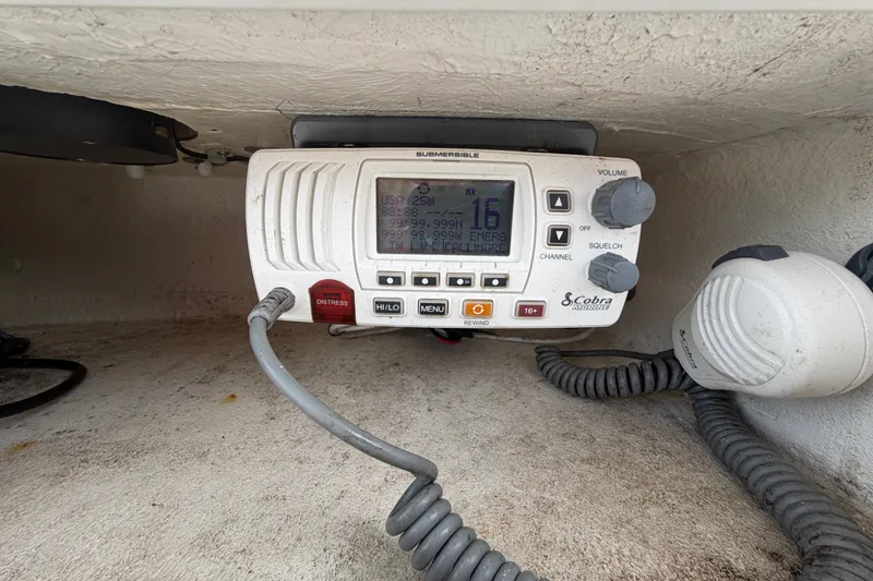 Slide: The Image of VHF marine radio on 2021 Dusky 227 Open Fisherman boat, featuring distress and channel controls. - 28