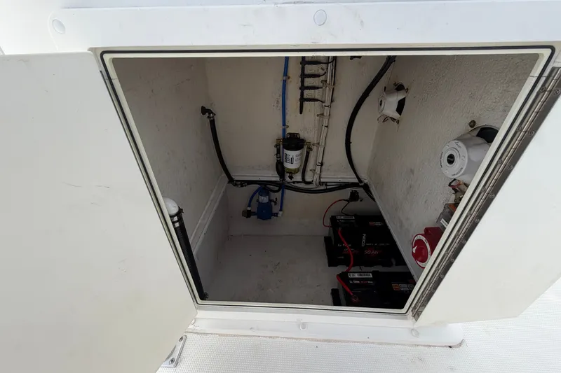 Slide: The Image of Open compartment of 2021 Dusky 227 Open Fisherman showing batteries and wiring. - 53