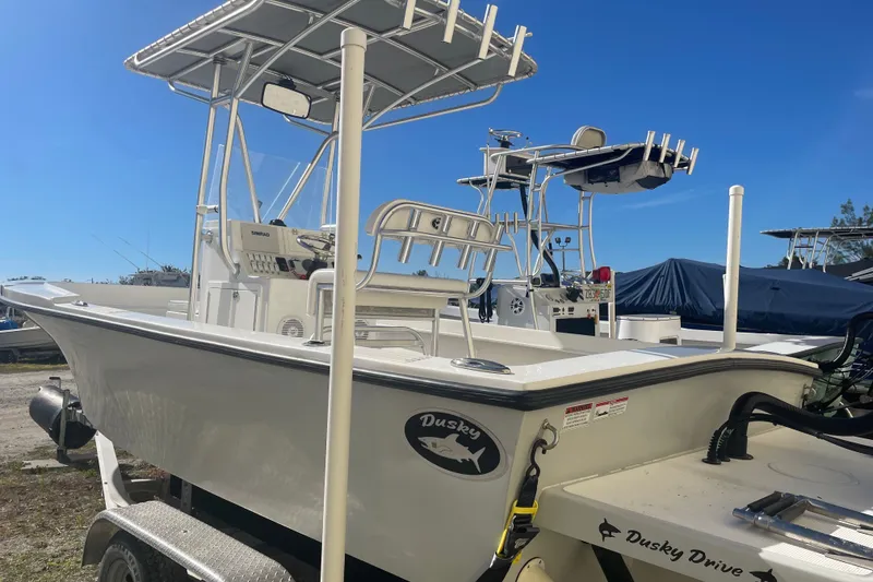 Slide: The Image of 2021 Dusky 227 Open Fisherman boat on trailer under clear blue sky. - 5