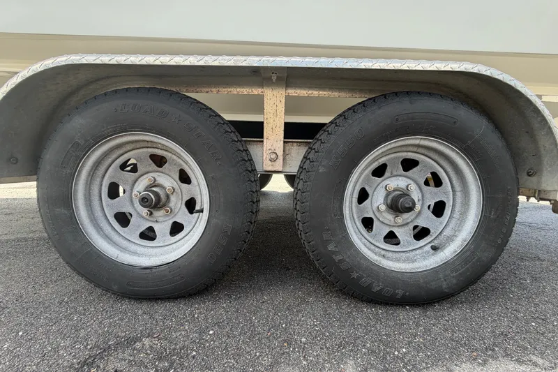 Slide: The Image of Trailer wheels of a 2021 Dusky 227 Open Fisherman boat on asphalt. - 64