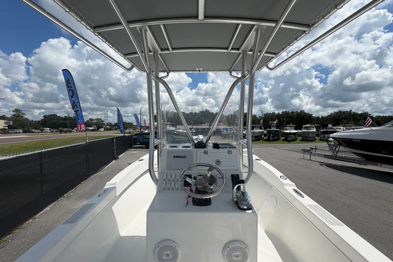 Slide: The Image of Dusky 227 Open Fisherman 2021 boat interior with steering console, displayed outdoors. - 18